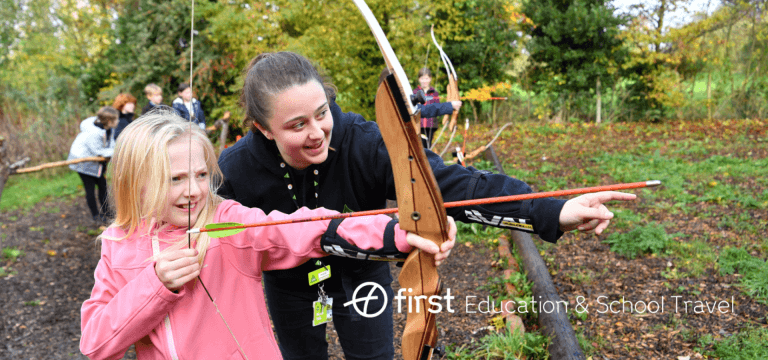 school pupil with instructor on an archery range