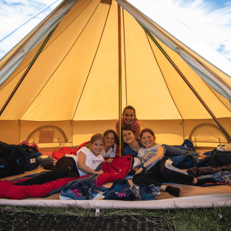 group of school students sat in a glamping tent