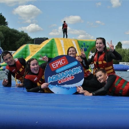 school trip group at aquapark on an inflatable in a lake