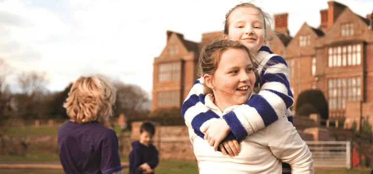 school pupils hugging each other outside an accommodation block