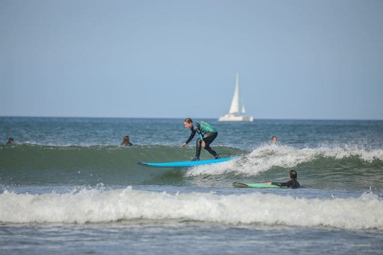 group of pupils surfing at the beach