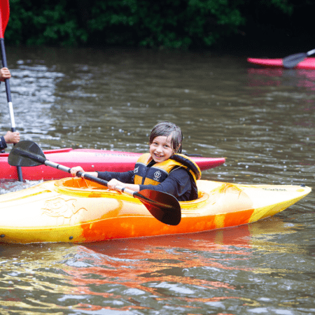 school pupil in a kayak on a lake