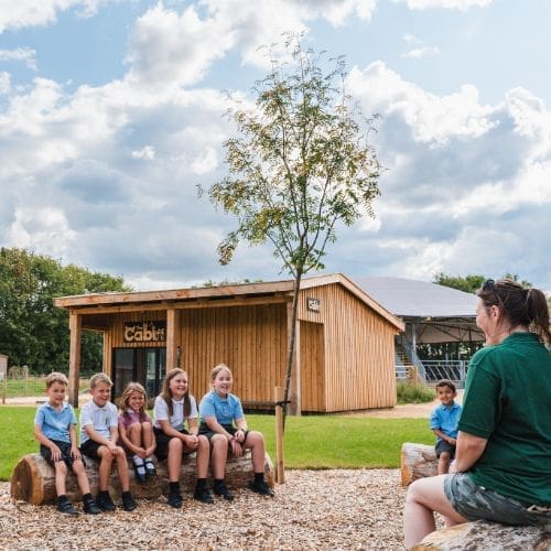 heritage instructor sat down outside presenting to a school group about what they do