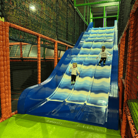 primary school pupils on an indoor slide at an activity and soft play centre