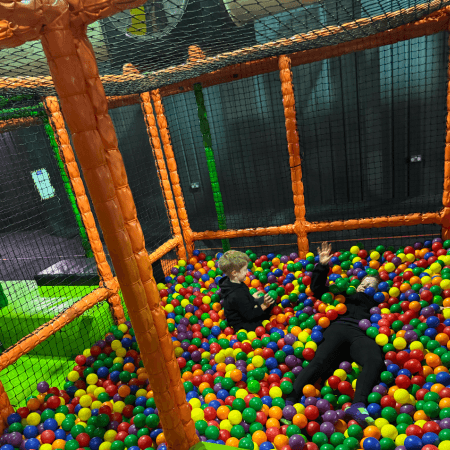 primary school children playing in a ball pit area at an activity indoor centre