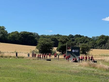 school pupils outdoors in a field doing sports
