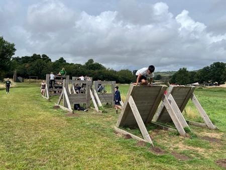 school pupils on an outdoor adventure assault course