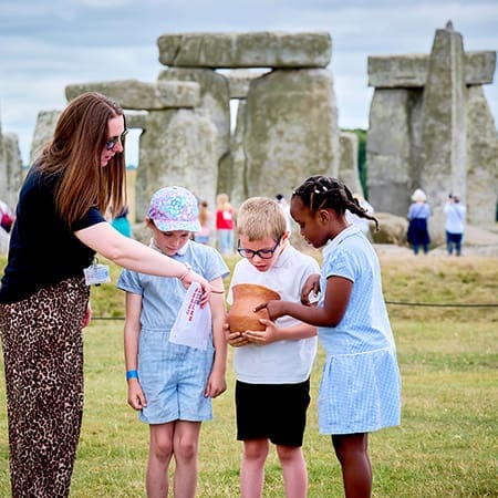 Examining a replica prehistoric beaker period pot