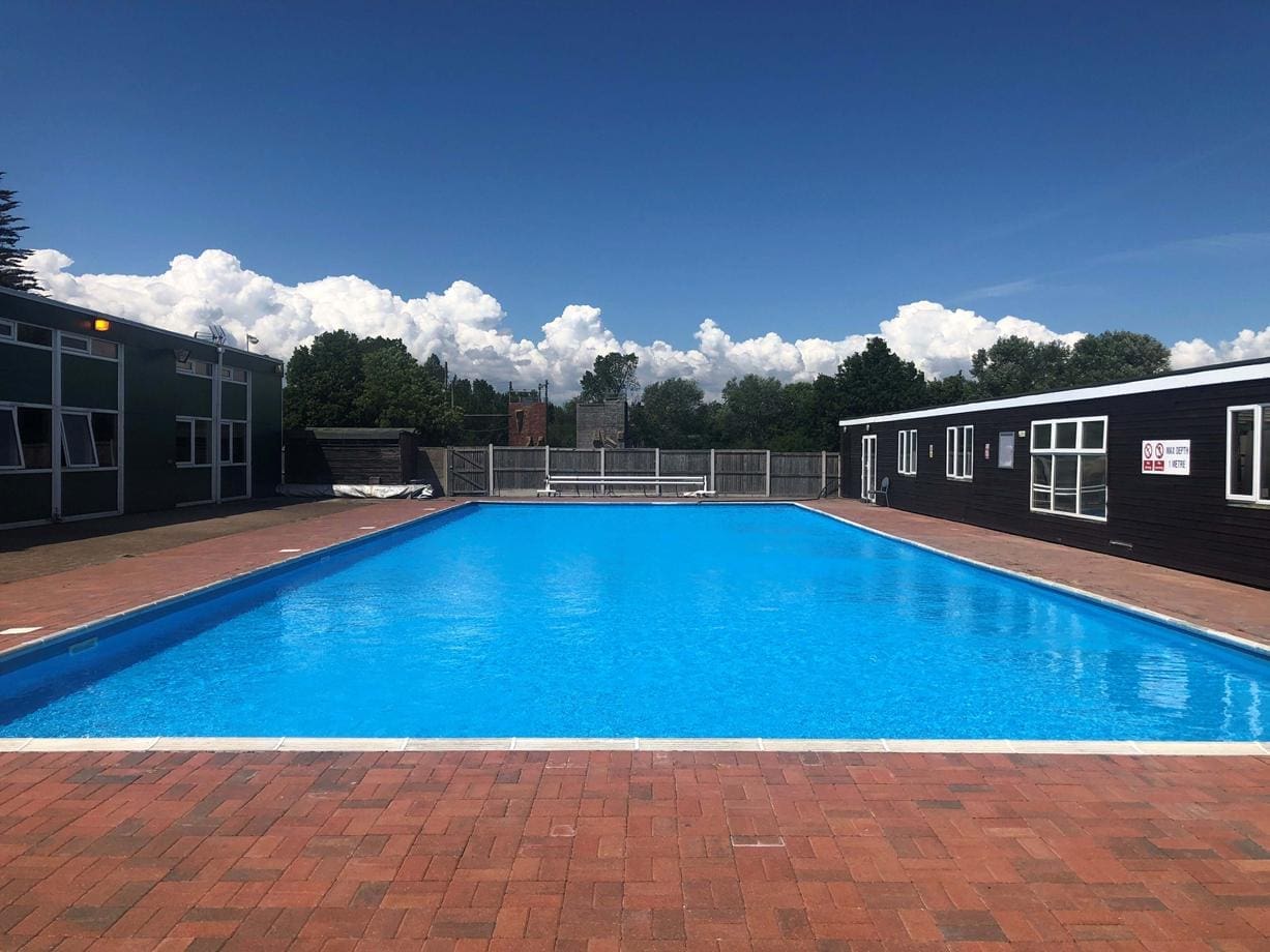 external drone shot of an outdoor swimming pool