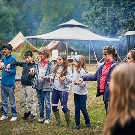 school group holding hands in a circle singing