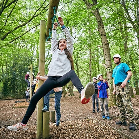 school pupil in the woods on a climbing ropes assault course