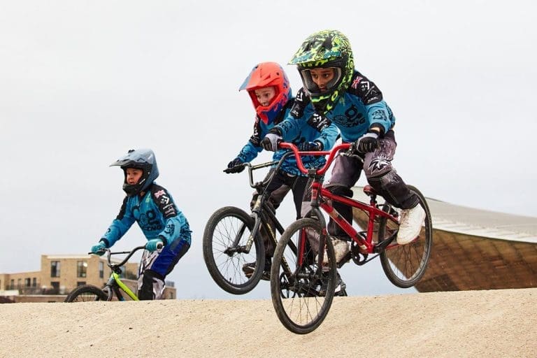 school students on BMX bikes going around a BMX track outside