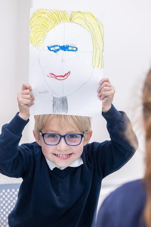 school boy with drawing of a human face