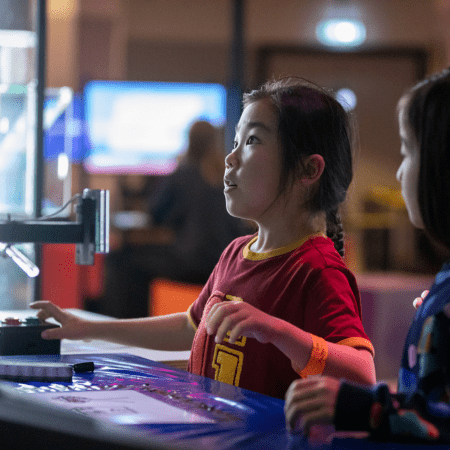 primary school pupils interacting with a machine at the Videogame Museum