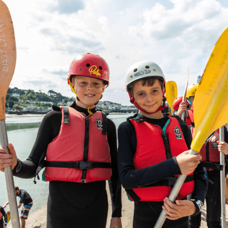 two school pupils with wet suits and paddles for kayaking