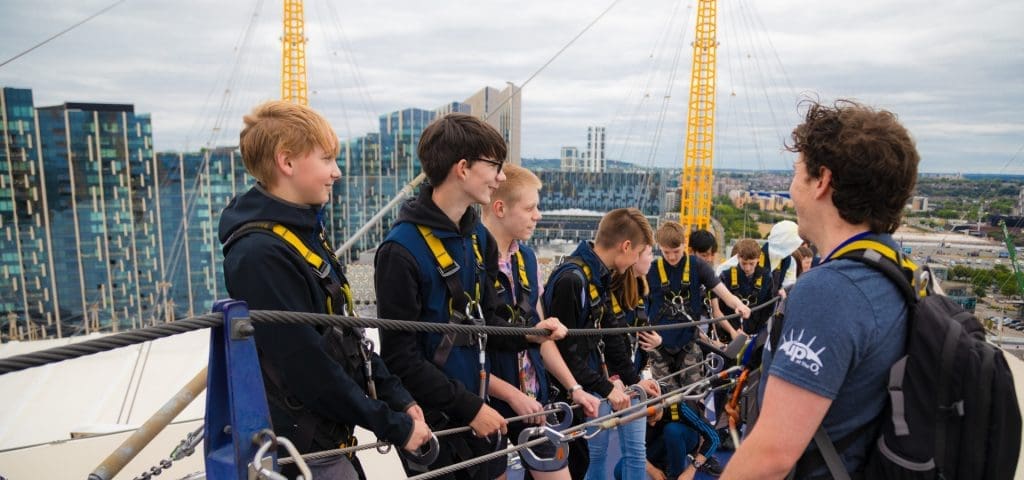 Up at the O2 London 7 school group standing on top of the O2 in London with safety equipment attached to a safety line