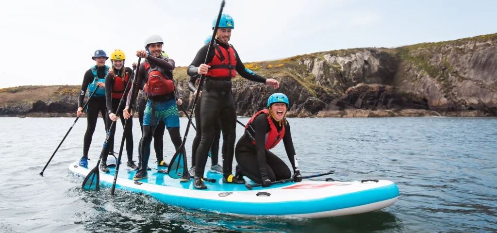 TYF Adventure Residential School Trips St Davids Pembrokeshire 6 group of school children on a massive inflatable paddle boat in the sea
