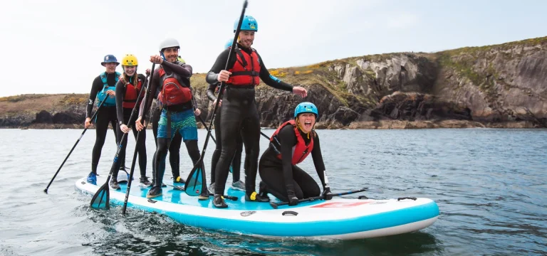 group of school children on a massive inflatable paddle boat in the sea