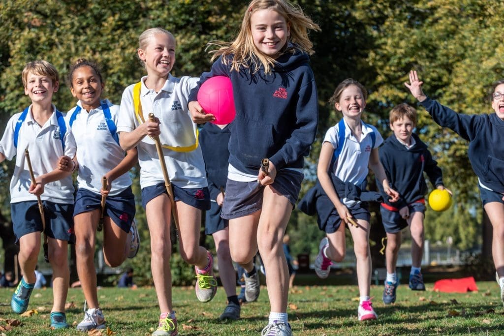 Quidditch for Muggles School Workshops London & the South East 3 school pupils running in a field with hockey sticks and balls