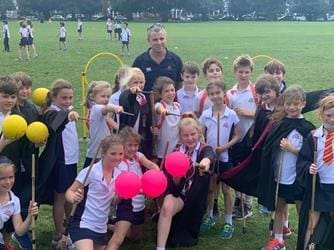 school group in a field outside doing quidditch
