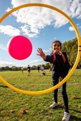 school pupil throwing a football in the air