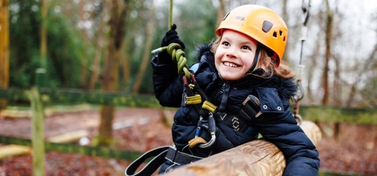 primary school pupil smiling climbing up an tower