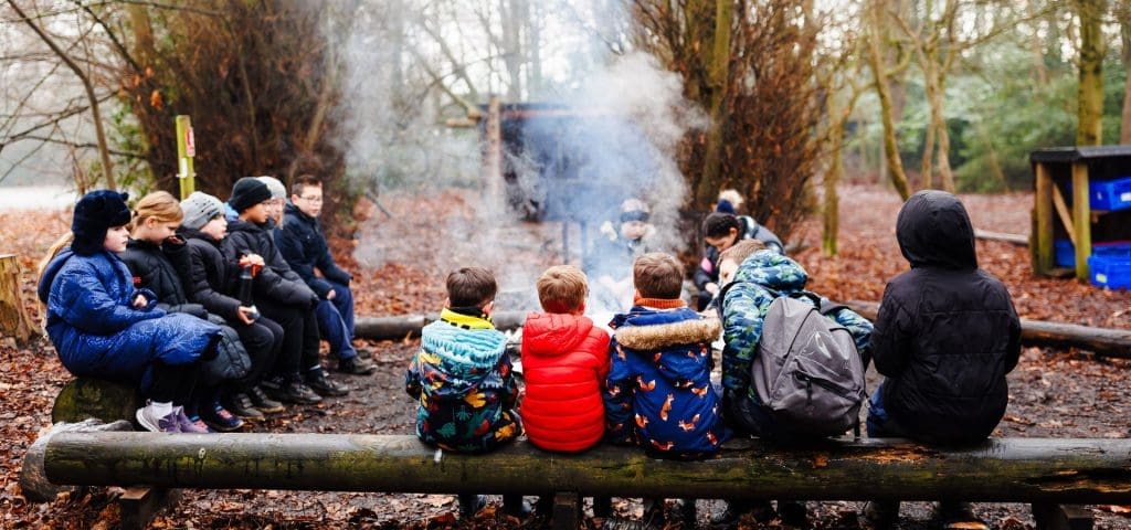 Scout Adventures Broadstone Warren Activity Centre Sussex 8 school group around a fire pit in the forest