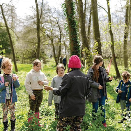 school trip students in field in the countryside with a teacher
