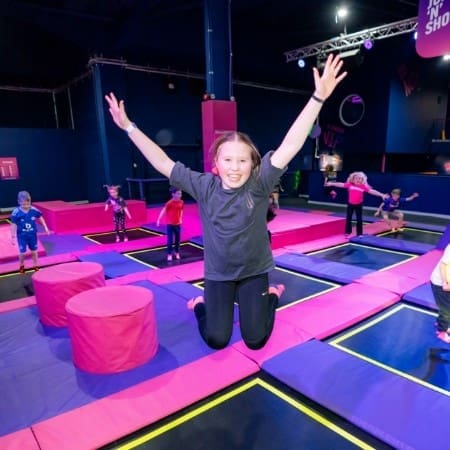 seconday school pupil jumpin high on a trampoline