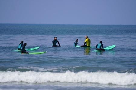 school pupil in the sea on surf boards