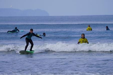 school pupil riding the waves on a surf board at the beach