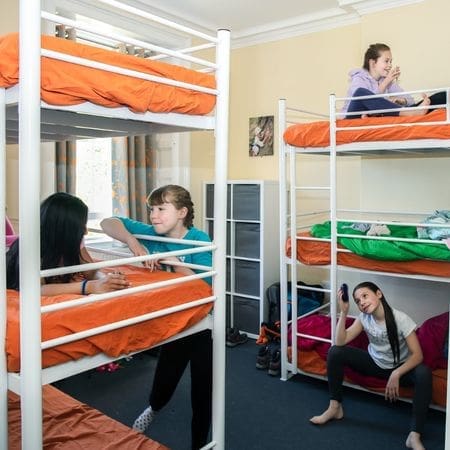 school pupils lying on top of bunkbeds in a dorm room