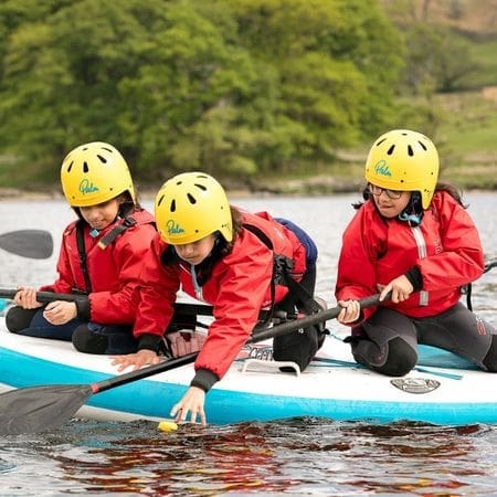 school pupils on paddle boards on a lake